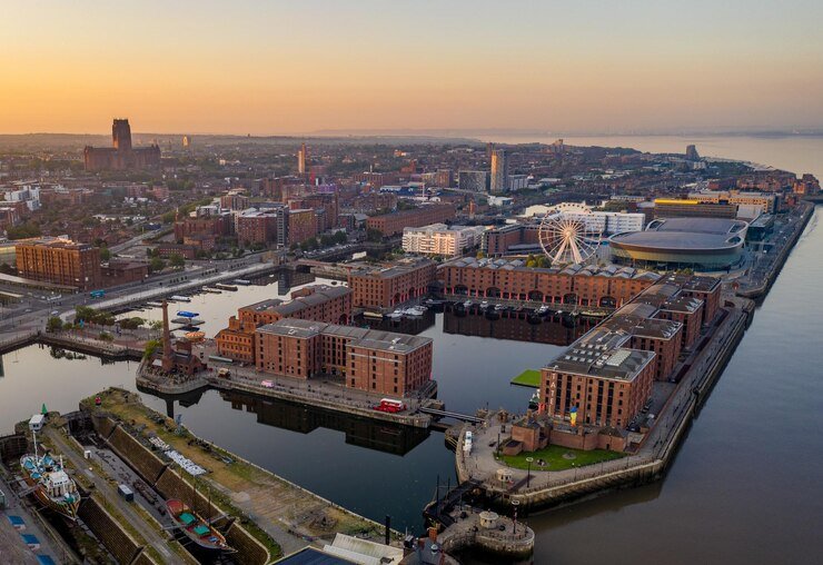 liverpool city - Manchester Airport Taxis Transfer Aerial view of Liverpool's waterfront featuring historic buildings, the iconic Liverpool Eye, and the vibrant city skyline at sunset, highlighting the cultural richness and scenic beauty of the city as a destination for travelers arriving from Manchester Airport.
