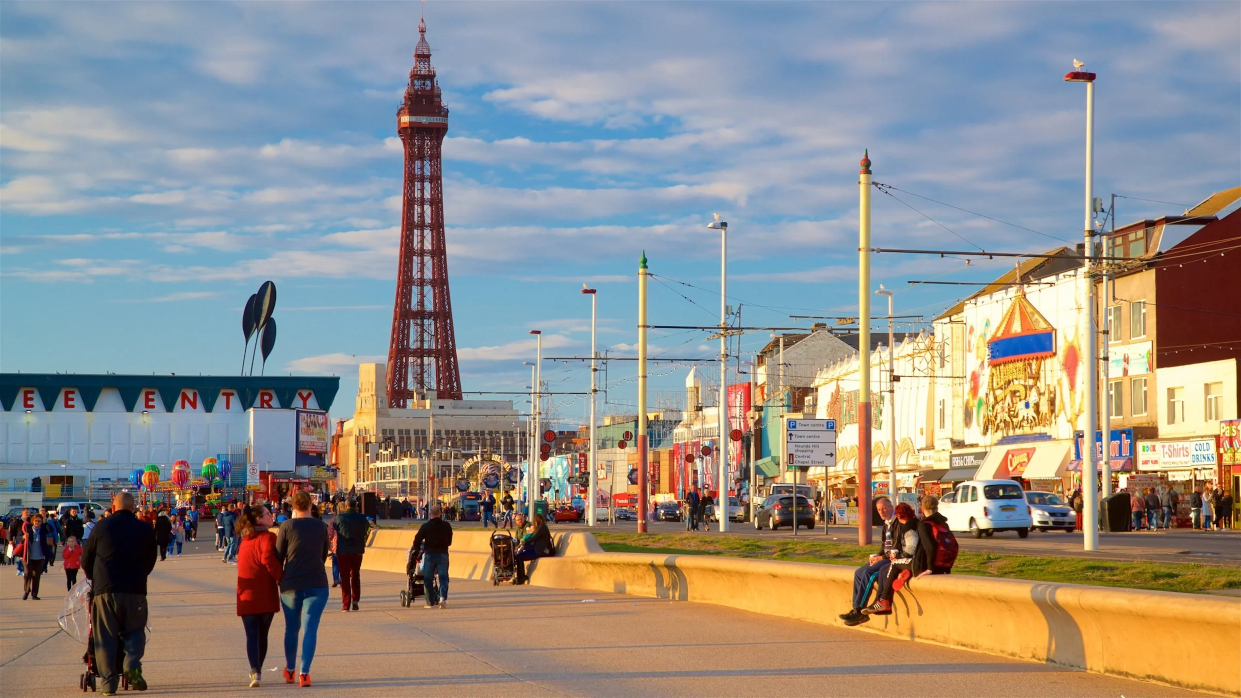 People walking along Blackpool Promenade with Blackpool Tower in the background. - Manchester Airport Taxi Transfer - Manchester Airport Taxi Transfer