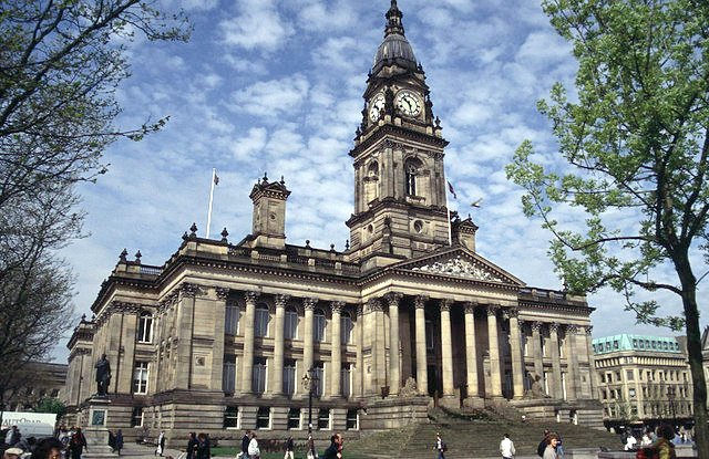 Historic stone city hall with clock tower against blue sky - Manchester Airport Taxi Transfer - Manchester Airport Taxi Transfer