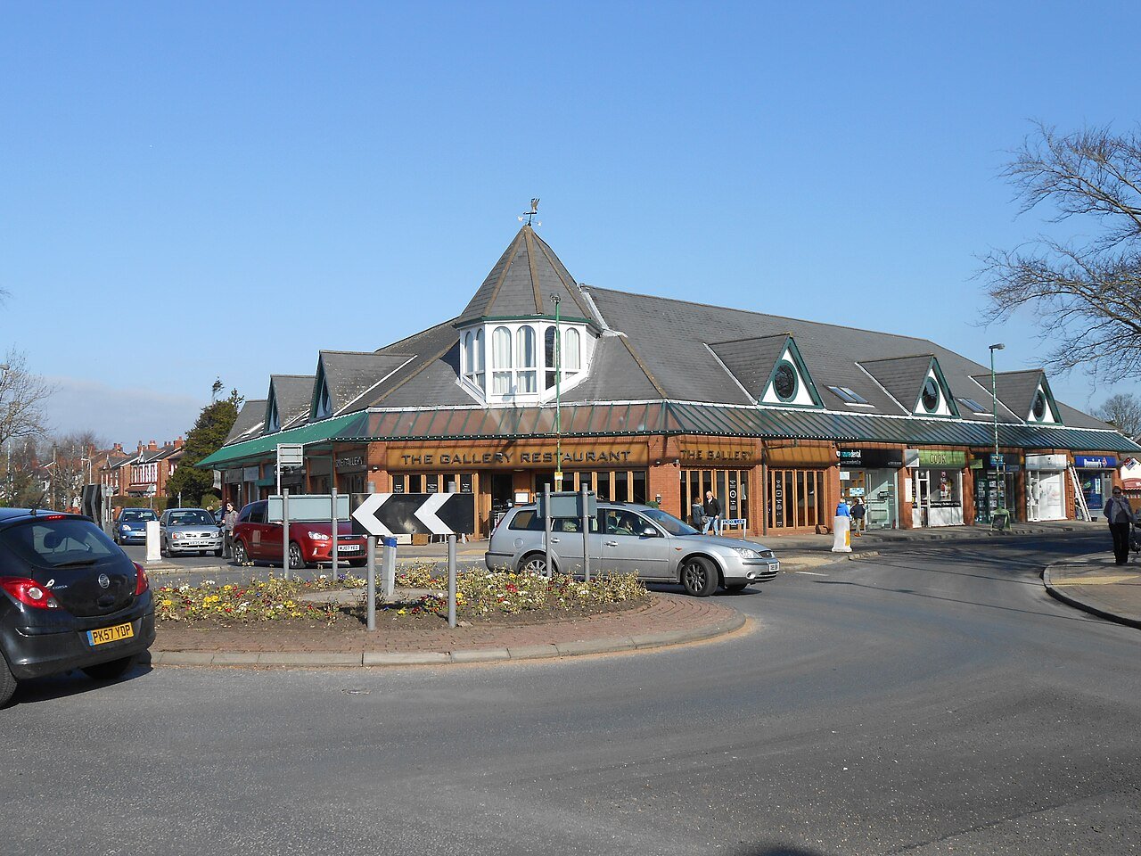 The Gallery Restaurant with distinctive roof at a UK town roundabout. - Manchester Airport Taxi Transfer - Manchester Airport Taxi Transfer