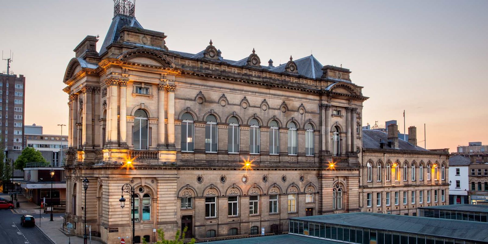 Grand Victorian sandstone civic building illuminated at dusk - Manchester Airport Taxi Transfer - Manchester Airport Taxi Transfer