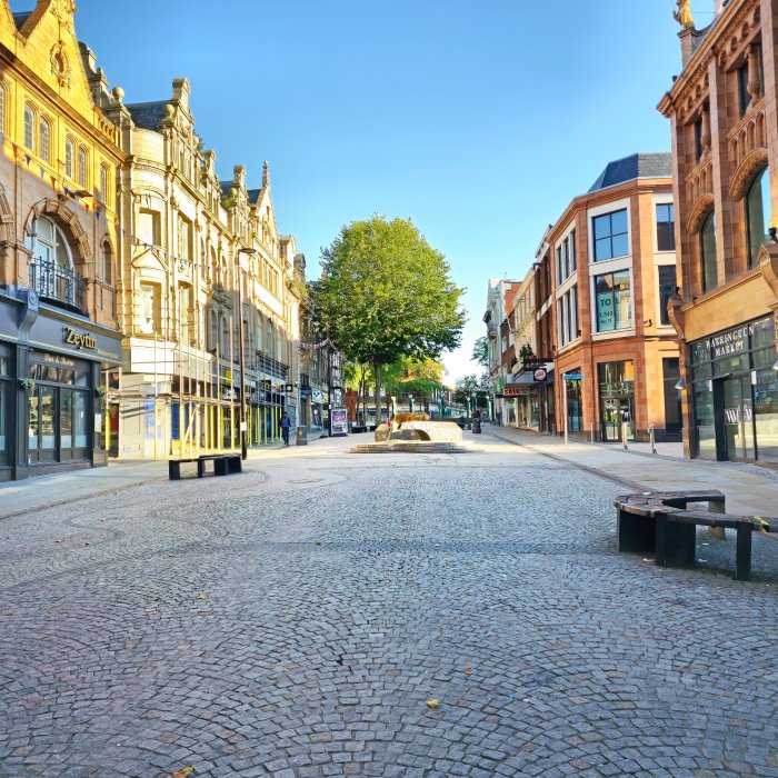 Warrington town centre empty cobblestone street with historic buildings and blue sky. - Manchester Airport Taxi Transfer - Manchester Airport Taxi Transfer
