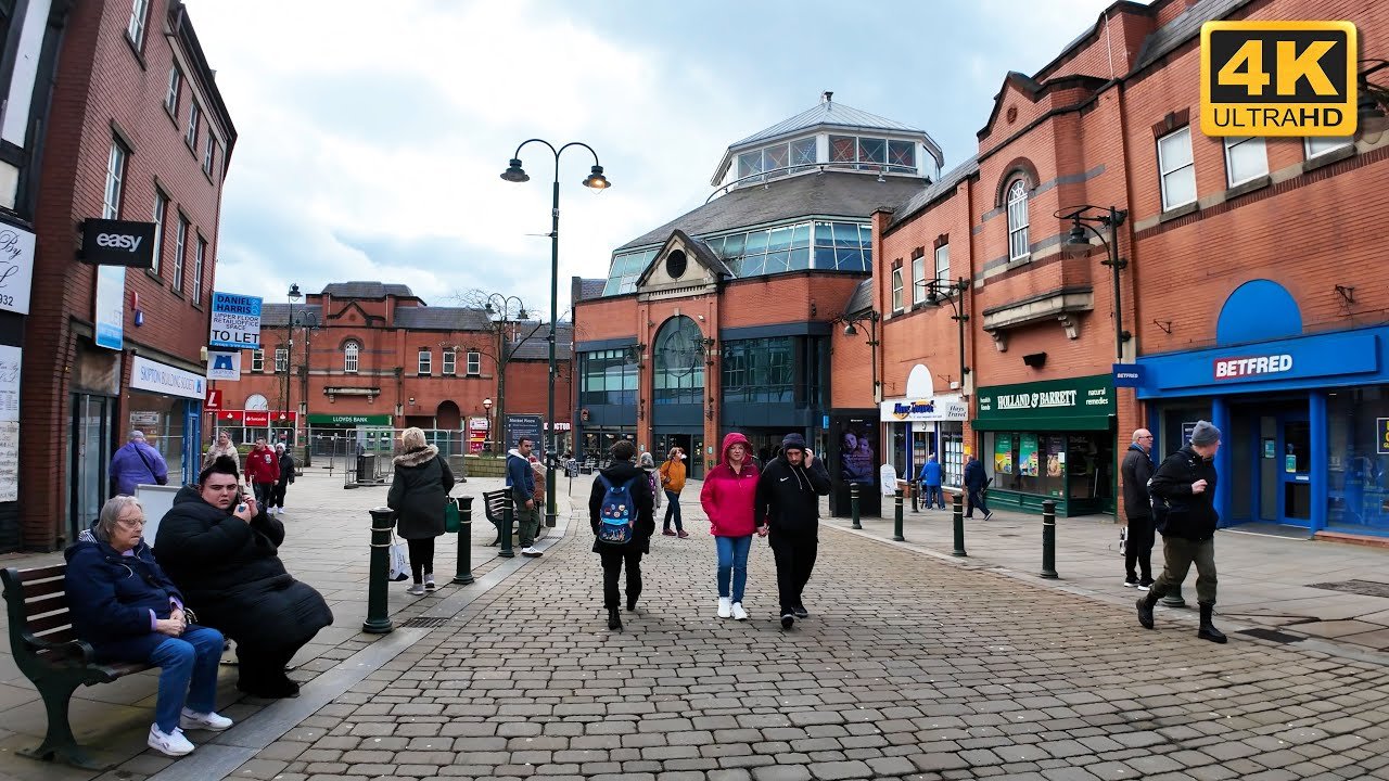 UK town centre pedestrian square with shoppers and brick buildings. - Manchester Airport Taxi Transfer - Manchester Airport Taxi Transfer