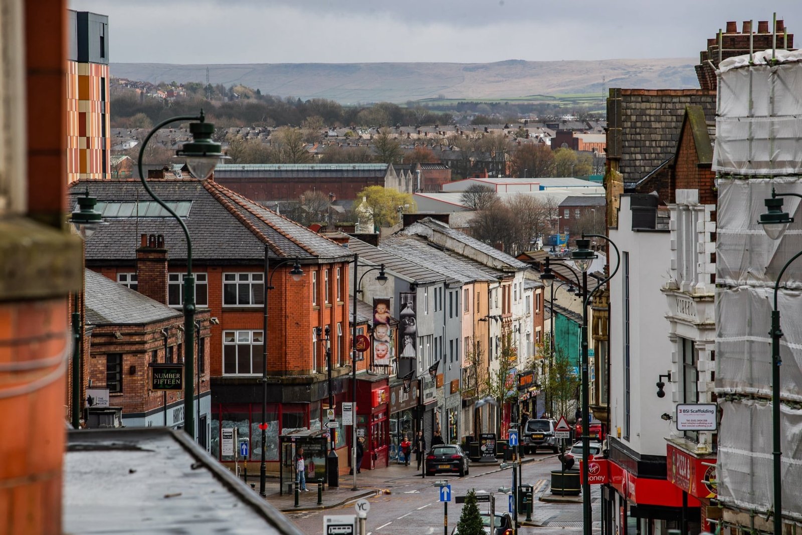 UK town high street with hills in background. - Manchester Airport Taxi Transfer - Manchester Airport Taxi Transfer